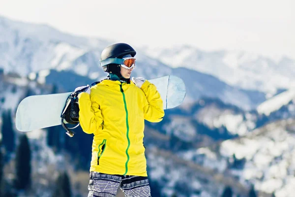 年轻女子滑雪板手肩膀上架着雪板 看着滑雪场 复制空间 — 图库照片