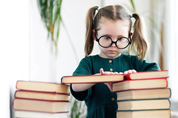 Caucasian little child girl in green dress and glasses procrastination while reading book — Stock Photo, Image