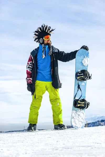 戴着滑雪面罩 戴着护目镜 头戴毛皮大莫霍克帽 背景是天空和冬季雪山的快乐雪人 — 图库照片