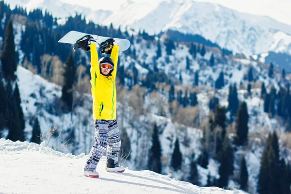 Giovane Donna Tiene Uno Snowboard Sopra Testa Uno Sfondo Montagne — Foto Stock