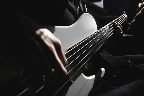 Vista Perto Guitarra Baixo Cinco Cordas Mãos Músico Iluminado Pela — Fotografia de Stock