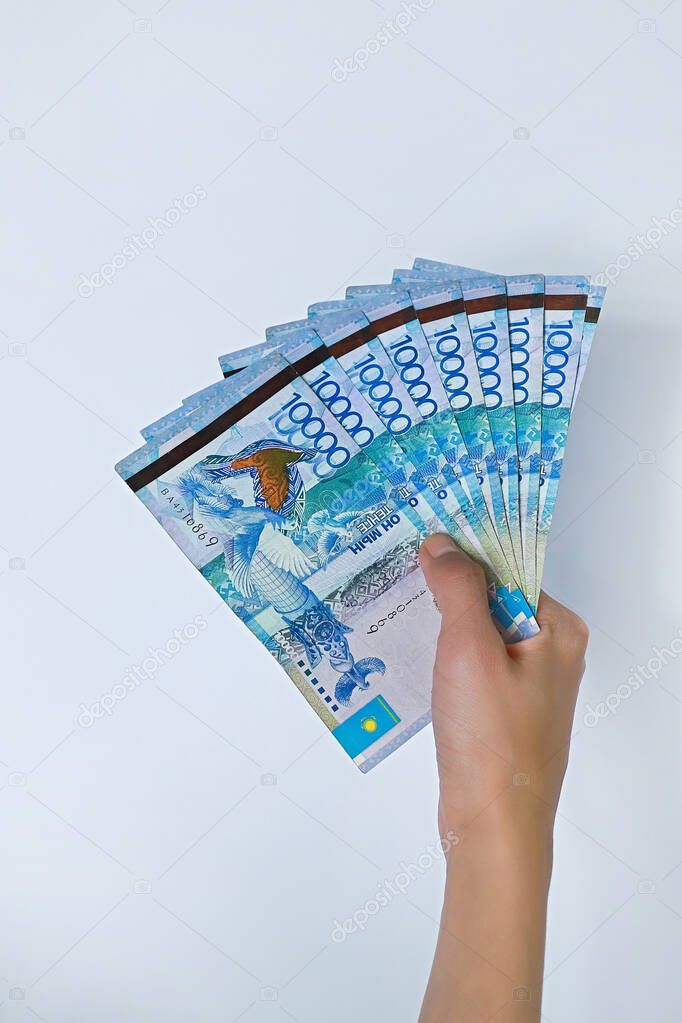 Tenge National currency of Kazakhstan in hand. Isolated on white background.