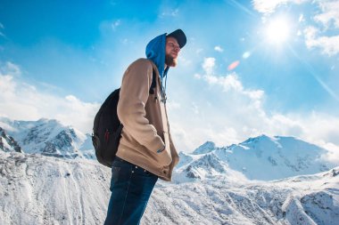 Sakallı mutlu bir adam dağlarda tek başına duruyor. Yaşam tarzı hayatta kalma.