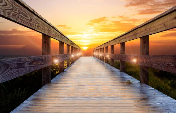 Akşamları okyanus rıhtımında ışıklar altında göz kamaştırıcı renkli bir gün batımı.