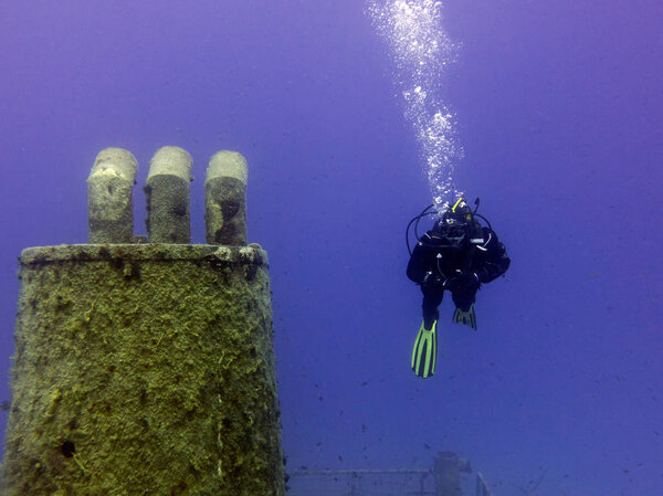 Dry suit diver on Um El Faroud shipwreck. Mediterranean, Malta.