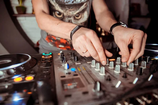 Dj mixes the track in the nightclub at a party