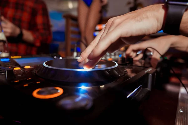 Dj mixes the track in the nightclub at a party