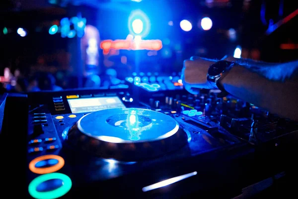 Dj mixes the track in the nightclub at party