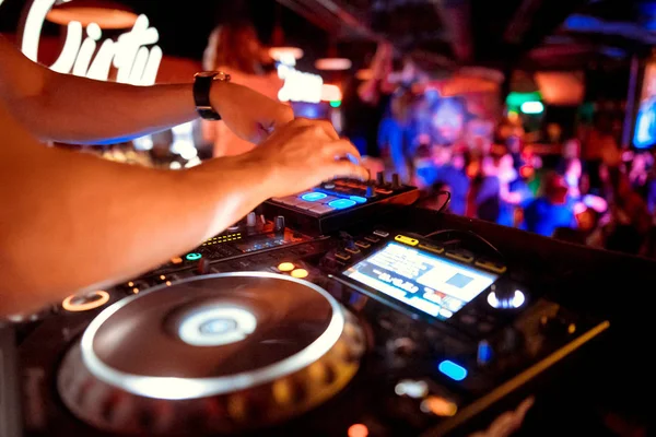 Dj mixes the track in the nightclub at party