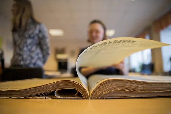 One open old book on a old oak wooden table. Beautiful dark background.