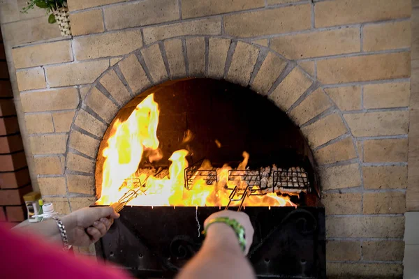 man cooks meat in the oven on fire