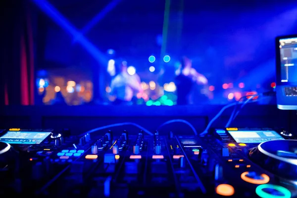 DJ behind the decks in a nightclub. DJ spinning plate. people dancing in a nightclub. disco