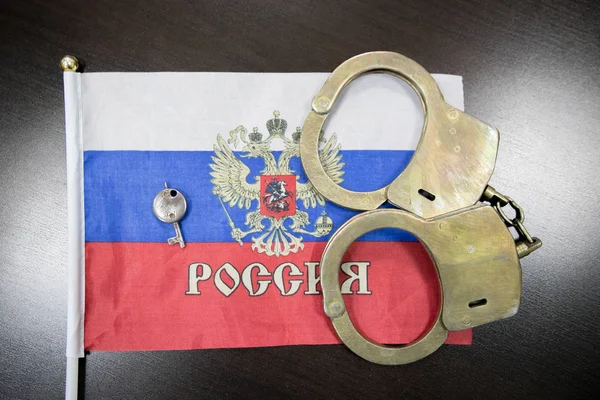 Russia flag  with handcuffs and a bundle of dollars. The concept of breaking the law and thieves crimes