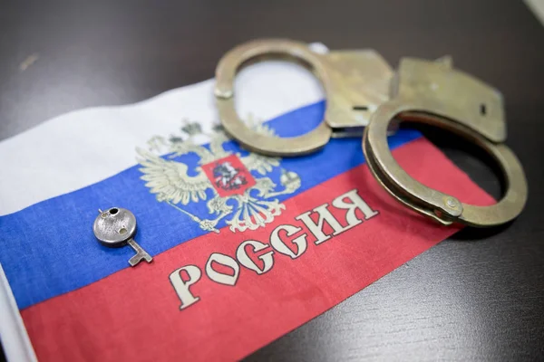 Russia flag  with handcuffs and a bundle of dollars. The concept of breaking the law and thieves crimes