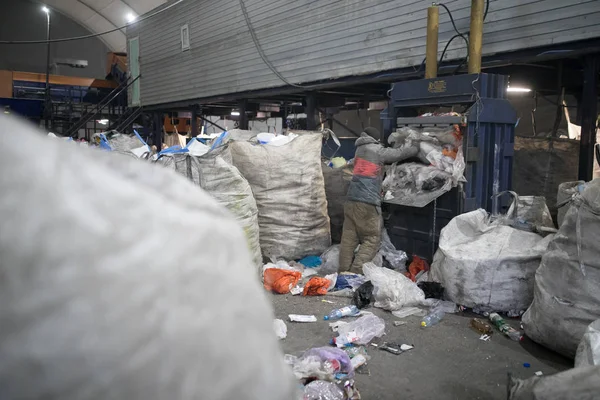 Press at waste recycling plant for pressing plastic and cardboard waste, processing