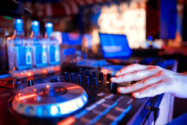 Dj mixes the track in the nightclub at party.