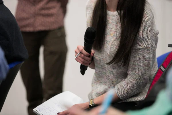 Microphone for interviewing and asking questions in news report, with blurred background of journalist