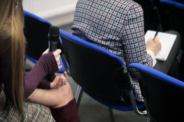 Microphone for interviewing and asking questions in news report, with blurred background of journalist