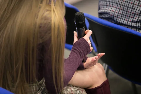 Microphone for interviewing and asking questions in news report, with blurred background of journalist