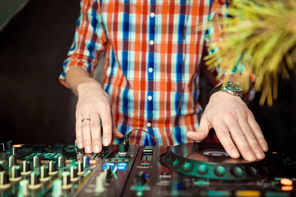 Dj mixes the track in nightclub at party