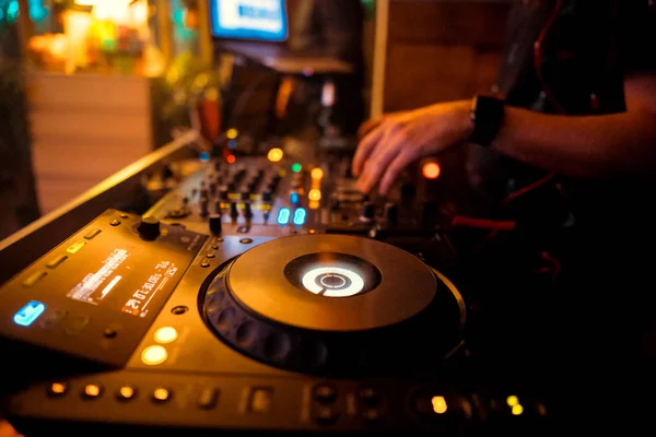 DJ behind the decks in a nightclub. DJ spinning plate. people dancing in a nightclub. disco