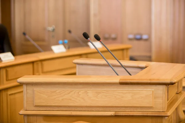 before a conference, the microphones in front of empty chairs.