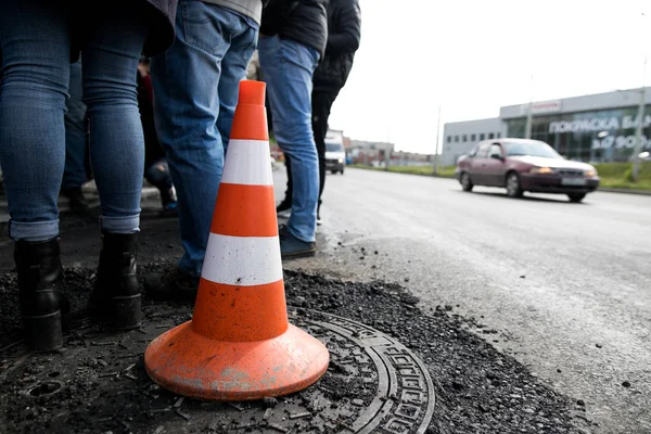 Work on road. Construction cones. Traffic cone, with white and orange stripes on asphalt. Street and traffic signs for signaling. Road maintenance, under construction sign and traffic cones on road.