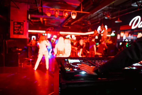 Dj mixing outdoor at beach party festival with crowd of people in background - Summer nightlife view of disco club outside - Soft focus on hand - Fun ,youth,entertainment and fest concept