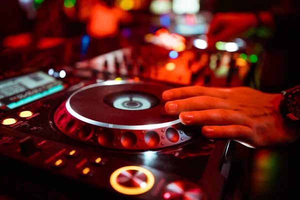 Dj mixing outdoor at beach party festival with crowd of people in background - Summer nightlife view of disco club outside - Soft focus on hand - Fun ,youth,entertainment and fest concept