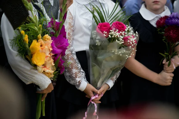 Flowers in the hands of schoolchildren. Bouquets in the hands of first-graders.