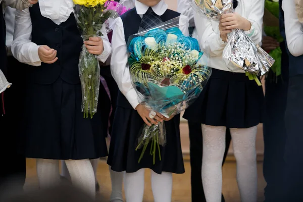 Flowers in the hands of schoolchildren. Bouquets in the hands of first-graders.