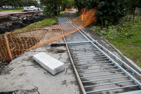 Laying or replacement of underground storm sewer pipes. Installation of water main, sanitary sewer, storm drain systems in city. Cast iron drainage pipe in ditch.