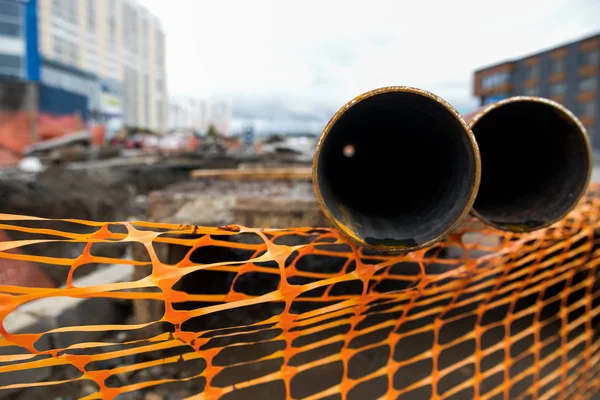 Laying or replacement of underground storm sewer pipes. Installation of water main, sanitary sewer, storm drain systems in city. Cast iron drainage pipe in ditch.