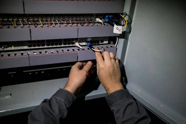 The technician attaching fiber optic on the Optical Distribution Frame. Man working in network server room with fiber optic hub for digital communications and internet.