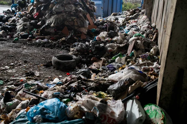 Garbage pile in trash dump or landfill, Waste from household in waste landfill, waste disposal in dumping site, excavator machine is working on a mountain garbage.