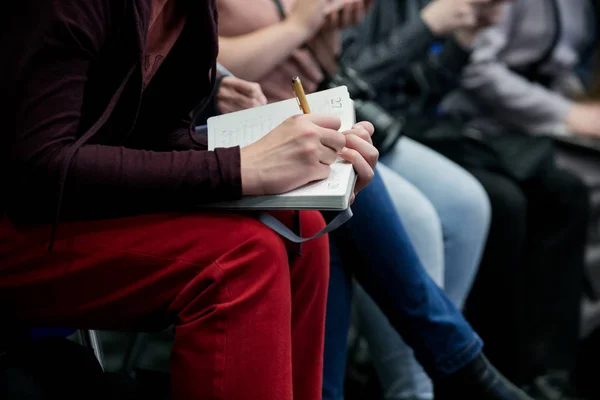 writes in a notebook at a meeting, political press conference, answers to a question