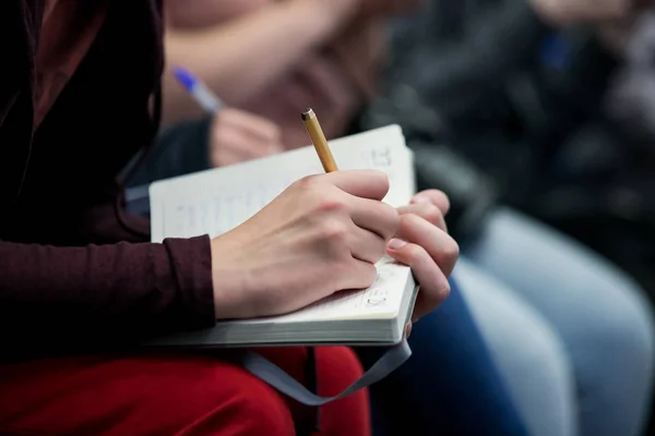 writes in a notebook at a meeting, political press conference, answers to a question
