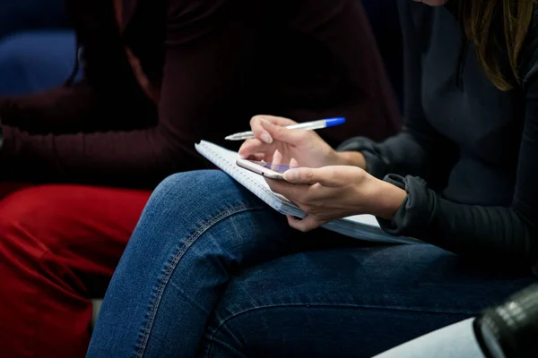 writes in a notebook at a meeting, political press conference, answers to a question