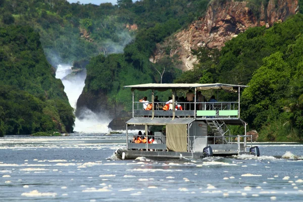 Bir çift düzey river cruise tekne yolcu alır Nil Nehri Murchison Falls'a Murchison Falls Milli Parkı, Uganda.