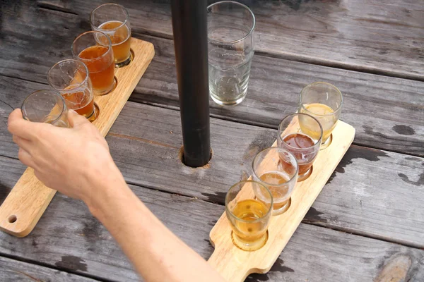 Hand Greift Nach Einem Bier Auf Dem Picknicktisch lizenzfreie Stockfotos