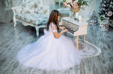 sevimli küçük kız stüdyoda beyaz elbise ve taç giyen Noel dekorasyonu ile poz