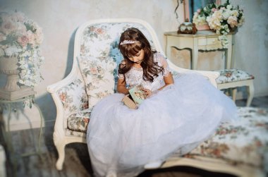 sevimli küçük kız stüdyoda beyaz elbise ve taç giyen Noel dekorasyonu ile poz