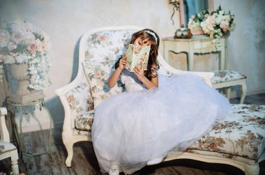 sevimli küçük kız stüdyoda beyaz elbise ve taç giyen Noel dekorasyonu ile poz