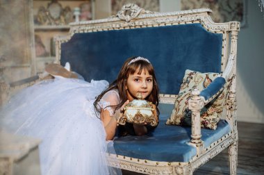 sevimli küçük kız stüdyoda beyaz elbise ve taç giyen Noel dekorasyonu ile poz