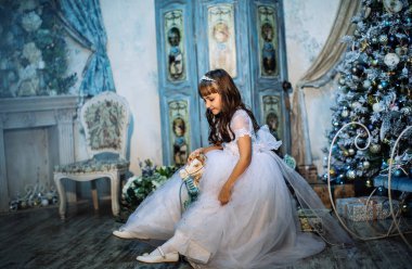 sevimli küçük kız stüdyoda beyaz elbise ve taç giyen Noel dekorasyonu ile poz