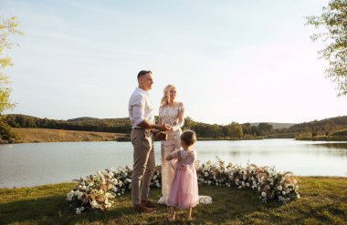 outdoor wedding ceremony , couple and little girl  clipart