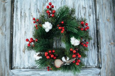 Noel çelenk köknar dalı dekore edilmiş pamuk ve kırmızı meyveler