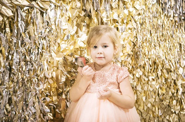 Schattig Meisje Blond Een Roze Jurk Een Gouden Achtergrond Kerst — Stockfoto