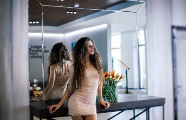 pahalı bir otelin aynada, poz nazik kısa elbiseli seksi kıvırcık kız