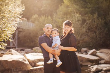 dağlar, Anne, baba ve Oğlu Asya gülmek ve kucaklama nehir yakınındaki bir yolda mutlu Kore aile